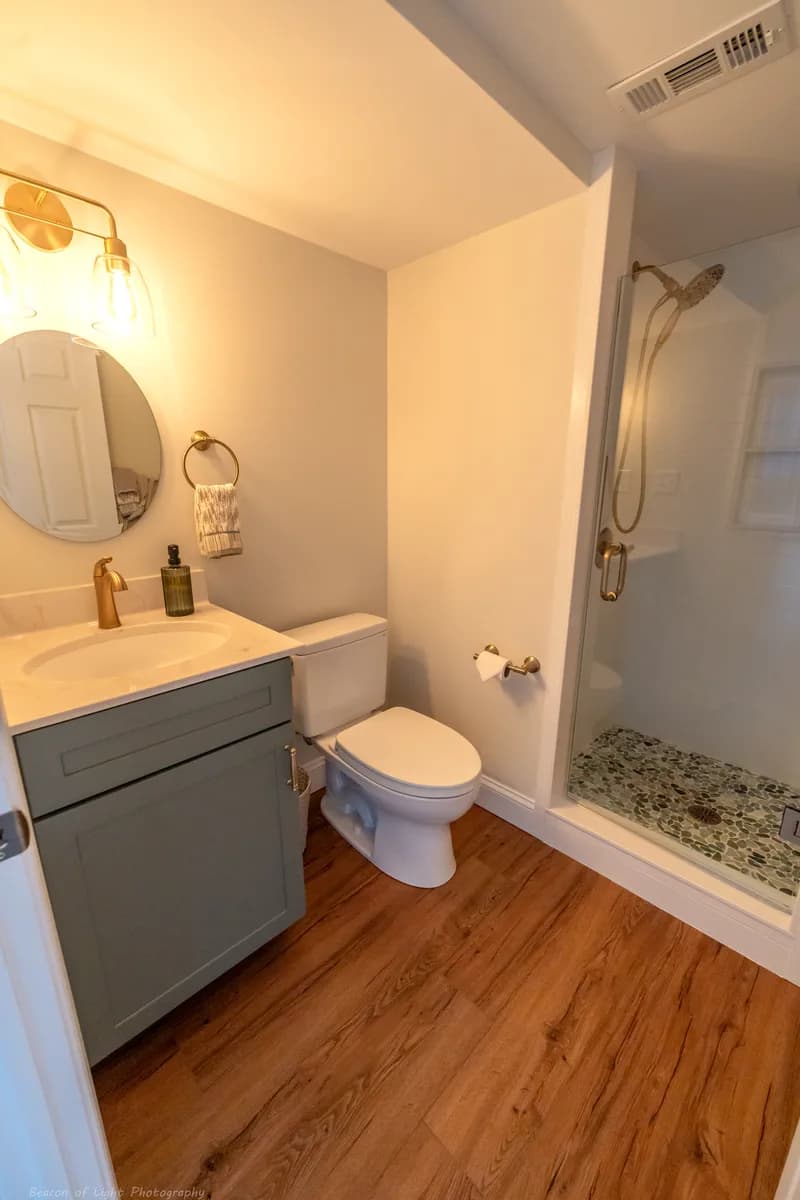 After — the expanded bath — glass shower, sage vanity