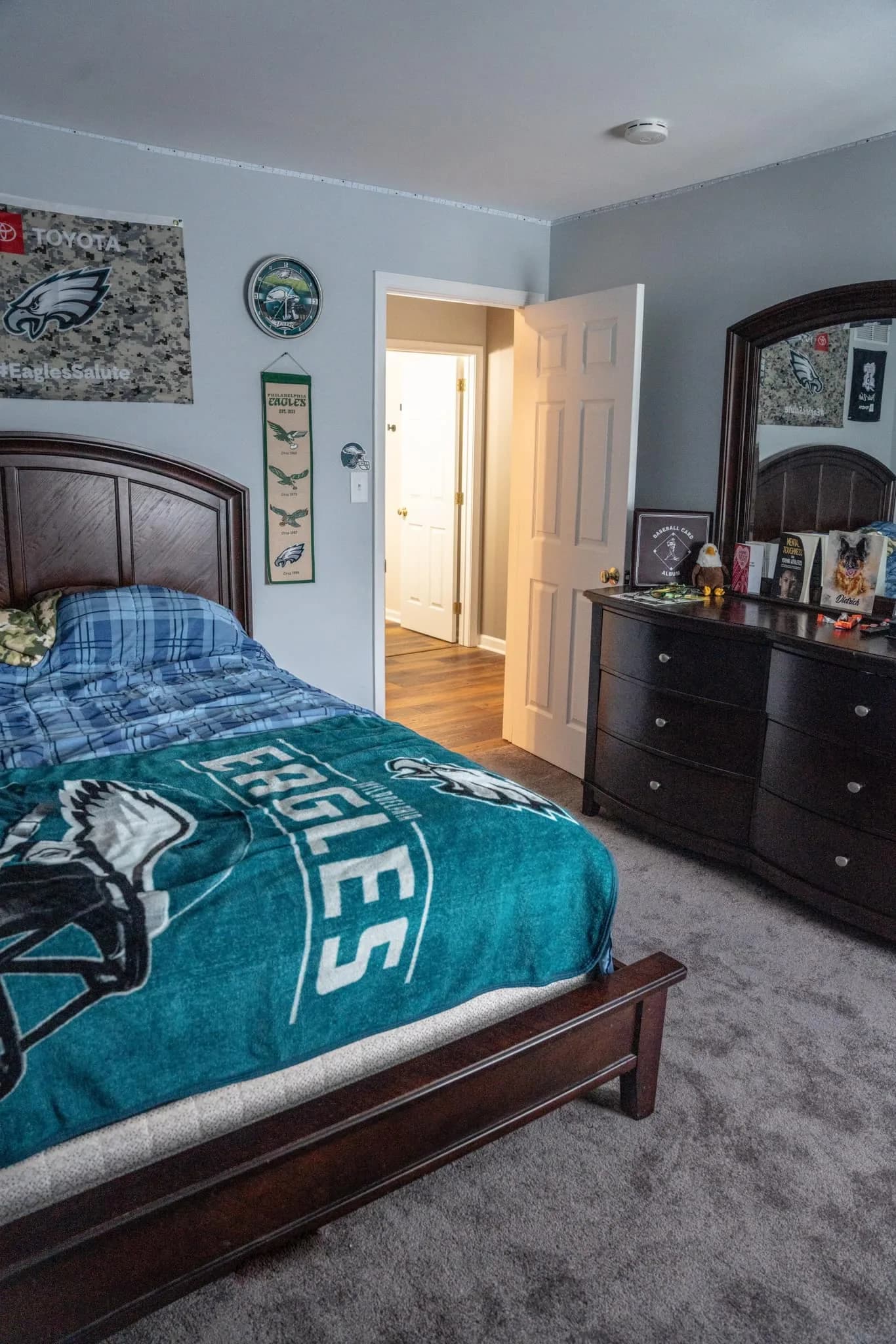 Second bedroom after the refresh — grey walls and carpet, sports-themed décor