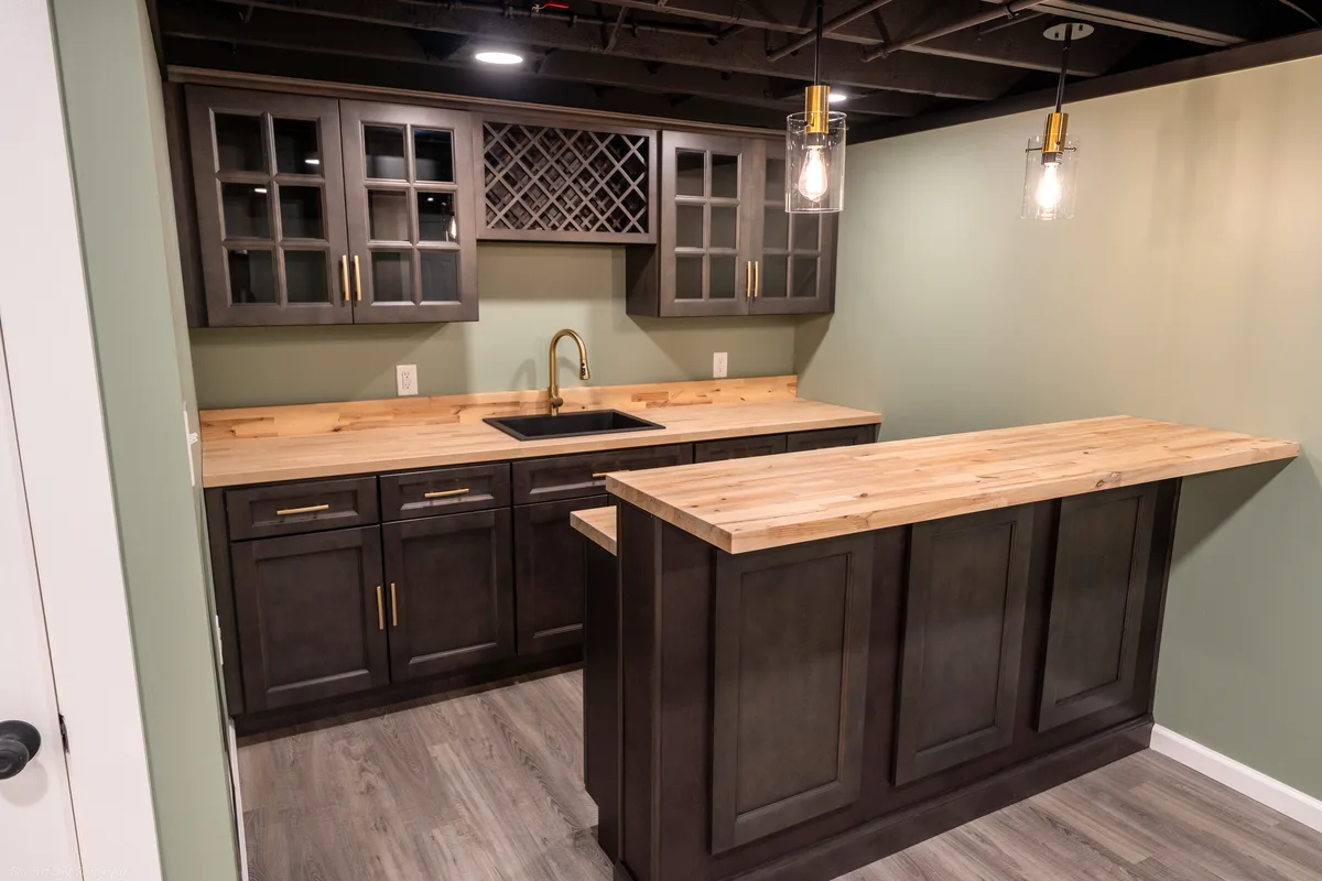 After — the wet bar — dark cabinets, butcher-block island