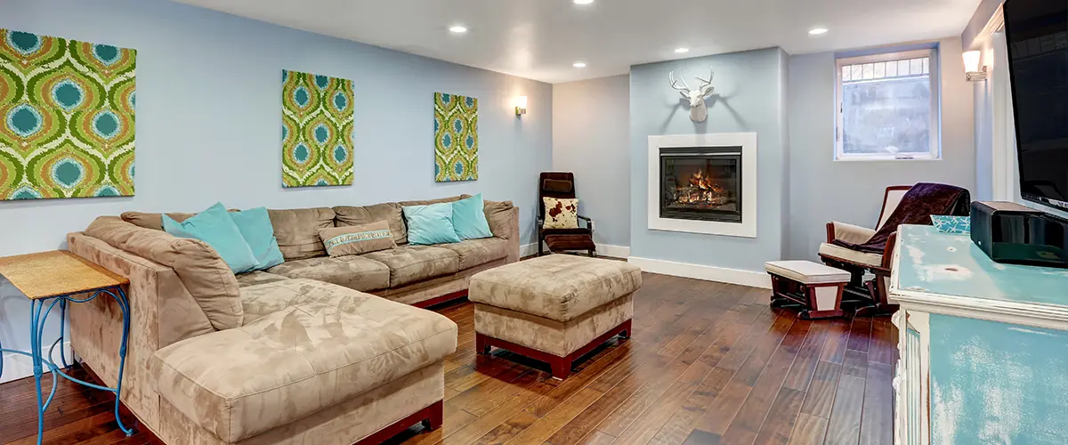 Cozy basement remodeling with a plush bed, decorative pillows, and natural light streaming through a large window.