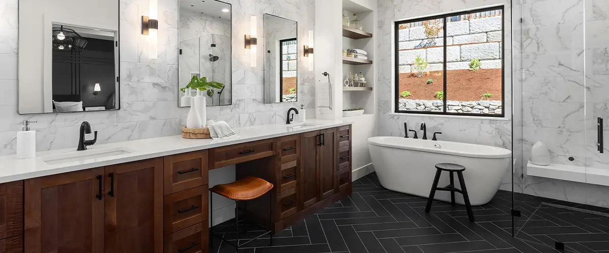 Luxurious bathroom remodeling, with marble wall, wooden double vanity, and freestanding bathtub.