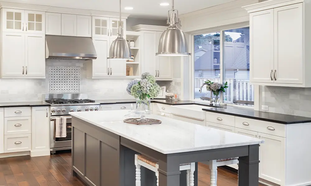 Bright kitchen with large island, white cabinetry, and stainless steel appliances