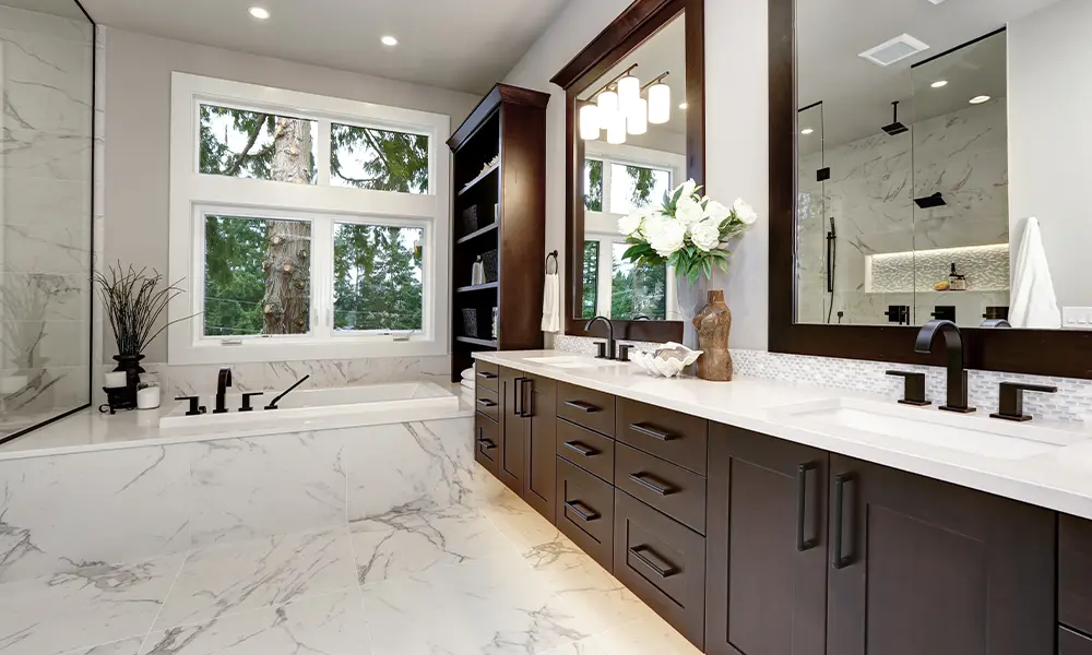 Luxurious bathroom with marble flooring, dark wood vanity, and large windows