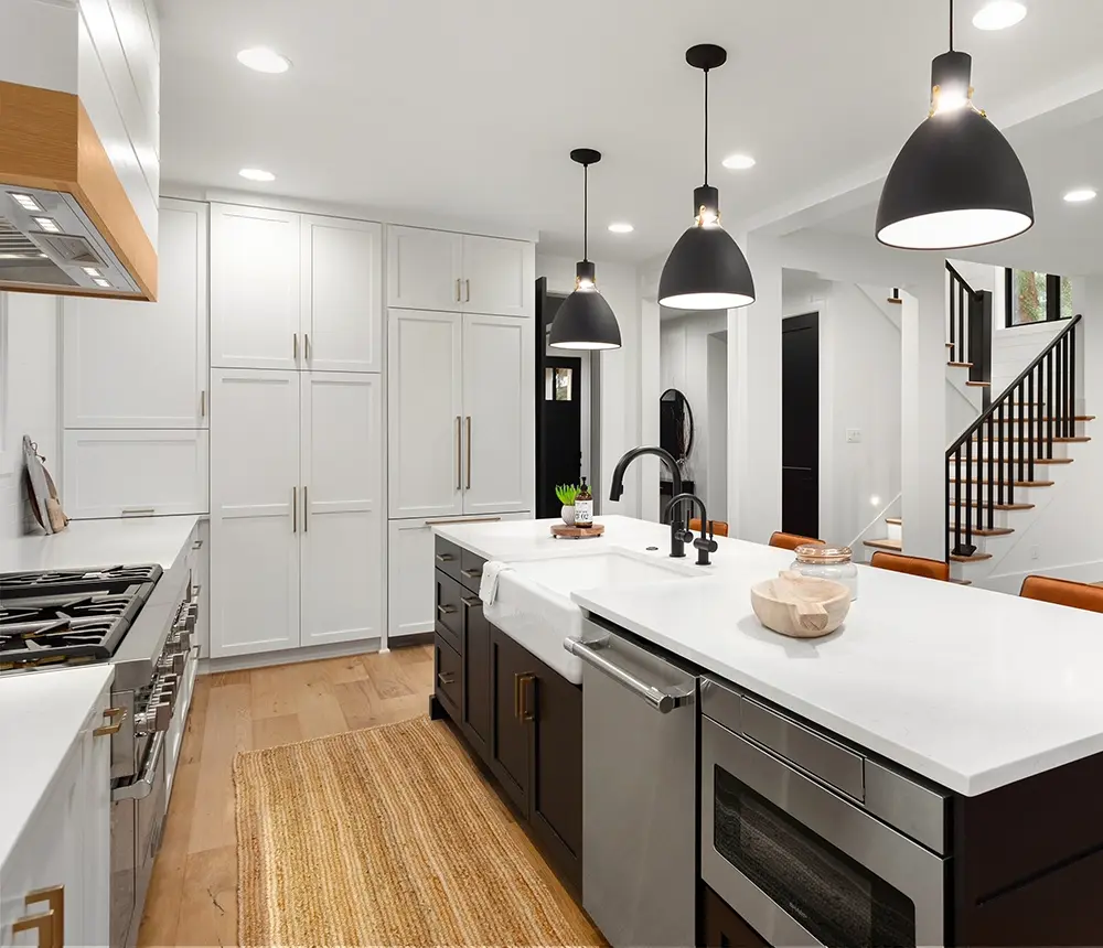 Contemporary kitchen with large island, pendant lights, and white cabinetry