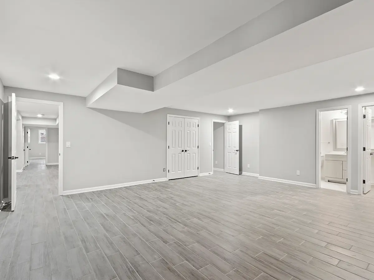 Newly remodeled basement with gray flooring and recessed lighting