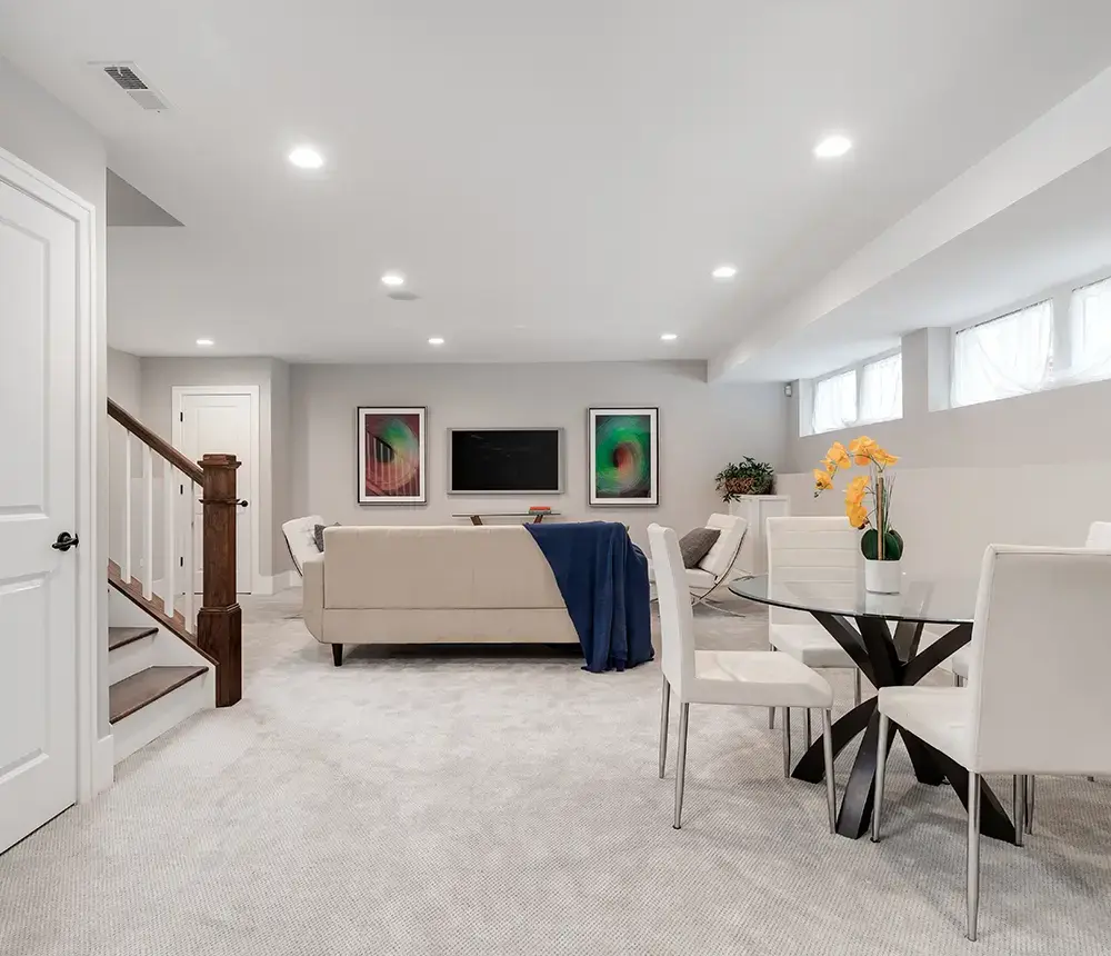 a living room in a basement with a couch and a table