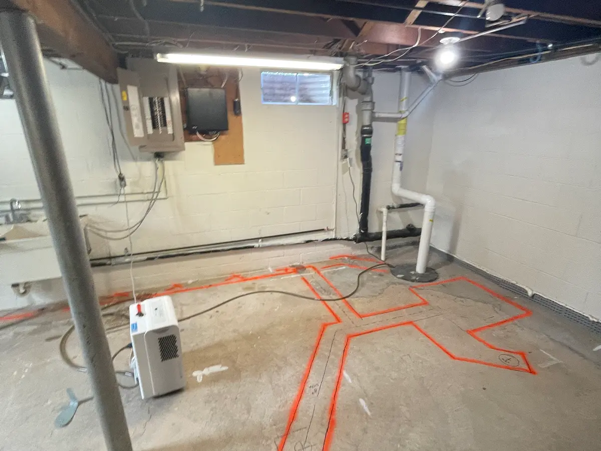 Unfinished basement with exposed wiring and concrete floor before remodeling