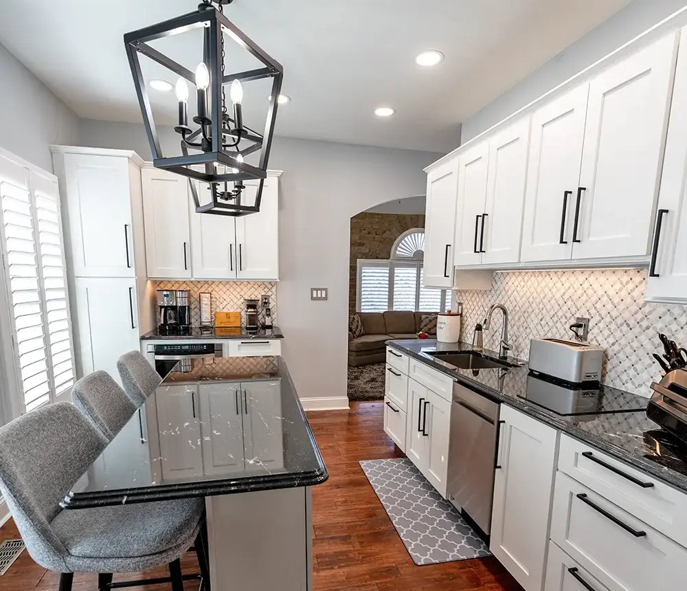 a new kitchen with a black countertop and white cabinets